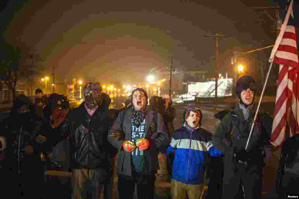 Protesters chant as they march for a third night of protests following the grand jury verdict in the Michael Brown shooting in Ferguson, Missouri, Nov. 26, 2014. 