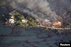 Lava destroys homes in the Kapoho area, east of Pahoa, during ongoing eruptions of the Kilauea Volcano in Hawaii, June 5, 2018.