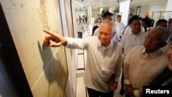 Ngoại trưởng Philippines Albert Del Rosario chỉ vào một bản đồ cổ trên màn hình bên cạnh Bộ trưởng Quốc phòng Voltaire Gazmin tại trường đại học Công giáo ở Manila (ảnh tư liệu năm 2014).