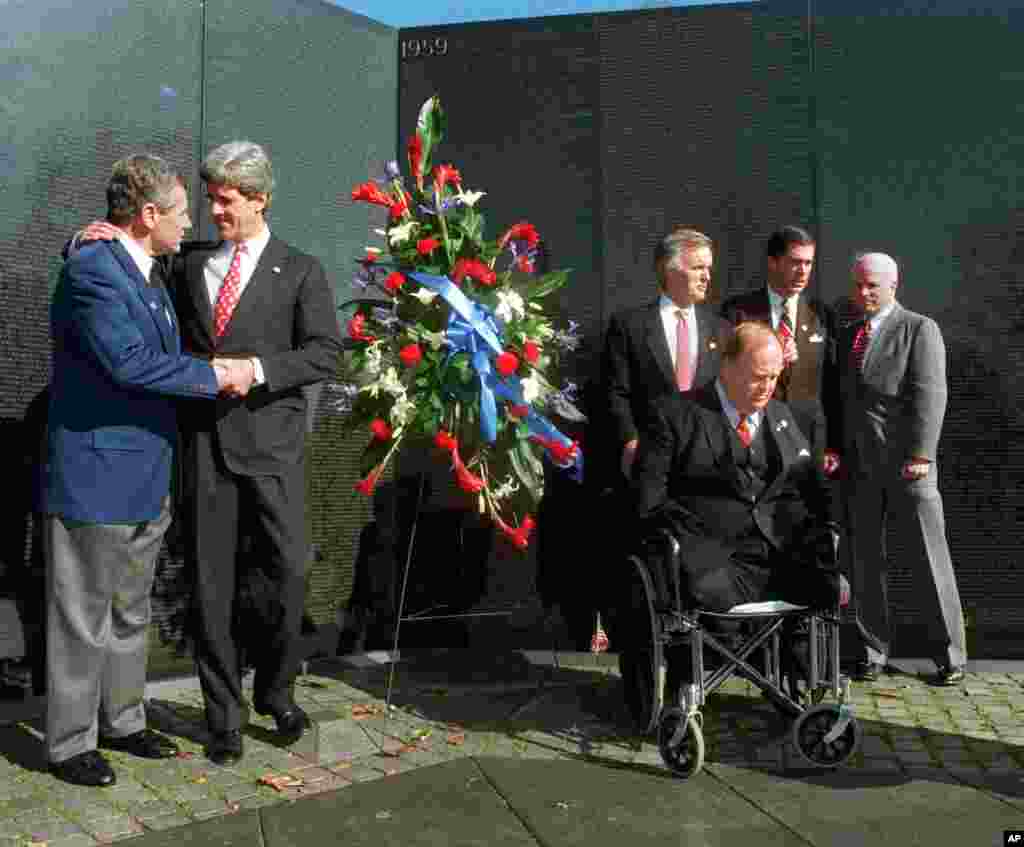 Senator Chuck Hagel, kiri, dan Senator John Kerry, berjabat tangan saat bersama dengan senator lainnya yang pernah mengabdikan diri di Vietnam pada ulang tahun ke-15 Vietnam Veterans Memorial, 7 Maret 1997.
