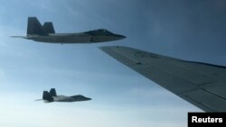 Two U.S. Air Force F-22 stealth fighter jets are about to receive fuel midair from a KC-135 refueling plane over Norway en route to a joint training exercise with Norway's growing fleet of F-35 jets, Aug. 15, 2018. 