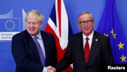 Le président de la Commission européenne, Jean-Claude Juncker, et le Premier ministre britannique, Boris Johnson, se serrent la main après avoir convenu de l'accord sur le Brexit, le 17 octobre 2019. REUTERS / Francois Lenoir 