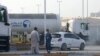Men stand outside a storage facility of oil giant ADNOC in the capital of the United Arab Emirates, Abu Dhabi, on January 17, 2022.
