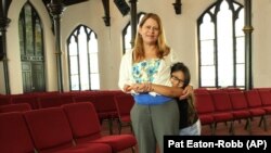 Nury Chavarria, 43, poses with her 9-year-old daughter, Hayley inside Iglesia De Dios Pentecostal church in New Haven on July 24, 2017. (AP Photo/Pat Eaton-Robb)