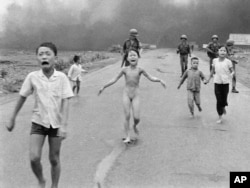 In this June 8, 1972 file photo taken by Huynh Cong "Nick' Ut, South Vietnamese forces follow terrified children, including 9-year-old Kim Phuc, center, as they run down Route 1 near Trang Bang after an aerial napalm attack on suspected Viet Cong hiding places.