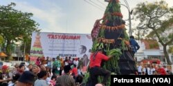 Masyarakat berebut gunungan tumpeng sayur mayur dan palawija yang dibuat relawan Jokowi di Surabaya pada acara Grebeg Suroboyo (foto Petrus Riski-VOA)