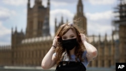 Estelle Fitz poses for a photo as she stands on Westminster Bridge in London, Wednesday, July 22, 2020. She said, "You should wear a mask for the safety of everyone," (AP Photo/Kirsty Wigglesworth)