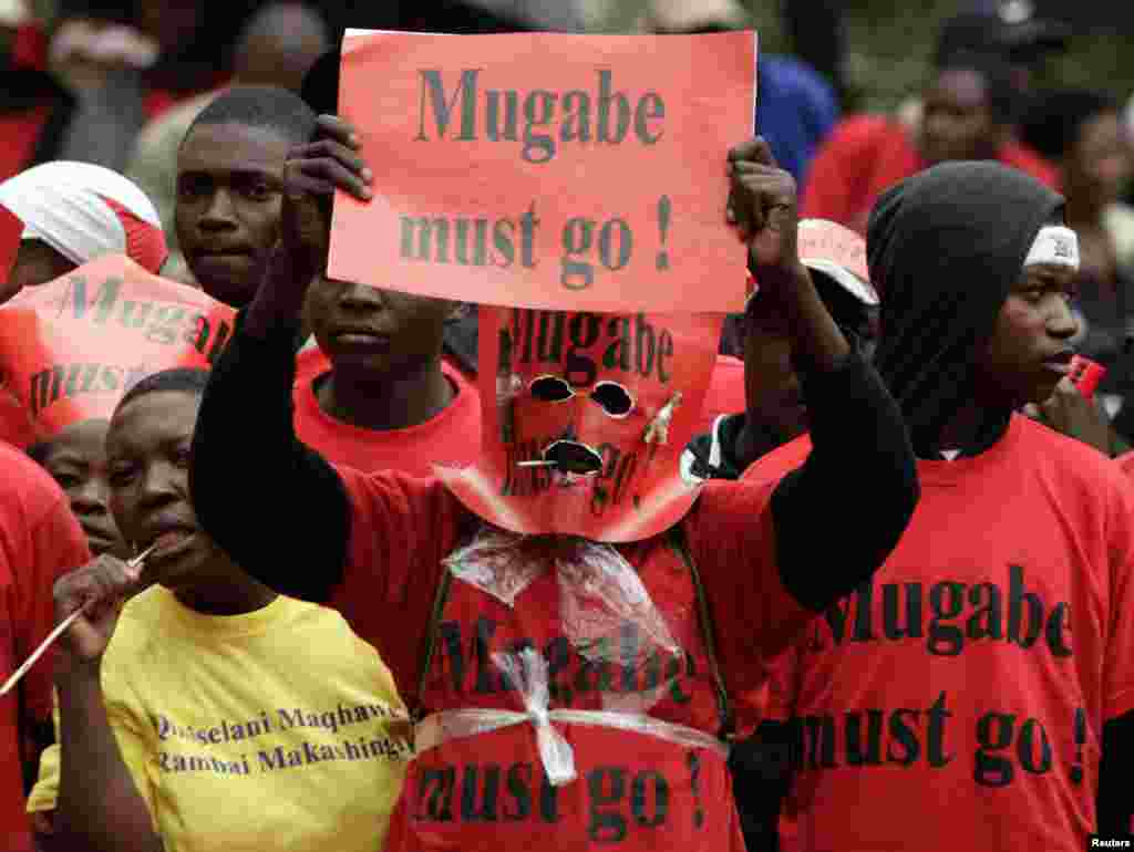 A Movement for Democratic Change (MDC) supporter holds a placard as they protest outside the venue of Southern African Development Community (SADC) meeting in Sandton November 9, 2008. Southern African leaders opened a regional summit on Zimbabwe in South Africa on Sunday, hoping to break a deadlock over the allocation of cabinet posts which has prevented formation of a power-sharing government.