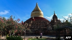 This photo taken on June 22, 2020 shows a woman clearing weeds in a temple complex in Bagan, Mandalay Region.