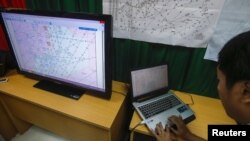 A Vietnamese officer prepares a flight route on a TV screen during a news conference about their mission to find missing Malaysia Airlines flight MH370 at Phu Quoc Airport on Phu Quoc Island, March 11, 2014.