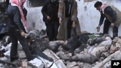 23일 시리아 하마시 외곽지역에 정부군의 공습이 있은 후, 무너진 건물 속에서 사체를 꺼내는 사람들.