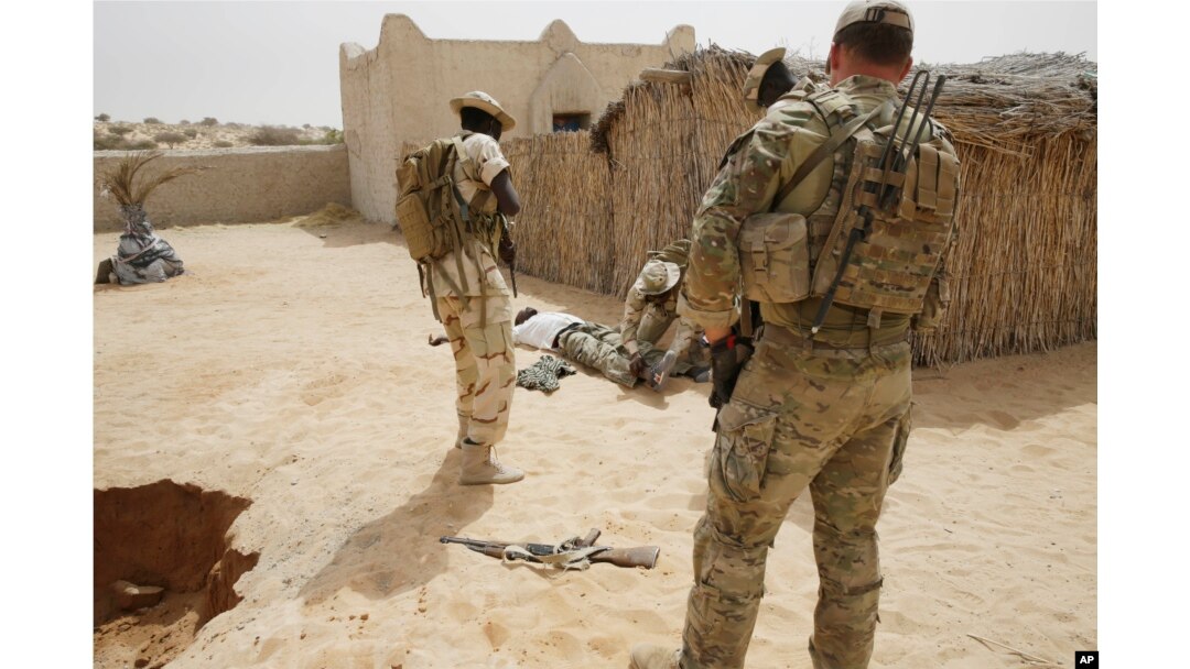 FILE - Chadian troops participate along with Nigerian special forces watched by a U.S. special forces soldier, at right, in a hostage rescue exercise in Mao, Chad, March 7, 2015.