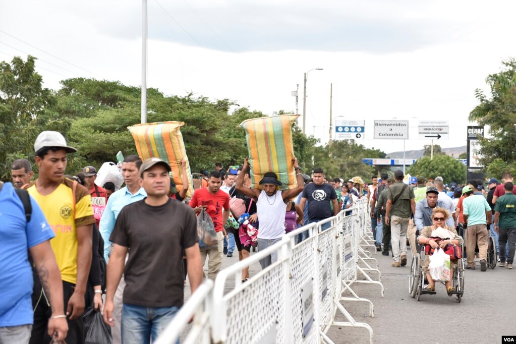 En el cruce hombres y mujeres jóvenes, y ancianos, que llevan a sus espaldas maletas llenas de ropa, mantas, o cualquier cosa que puedan cargar. (Foto: Diego Huertas)