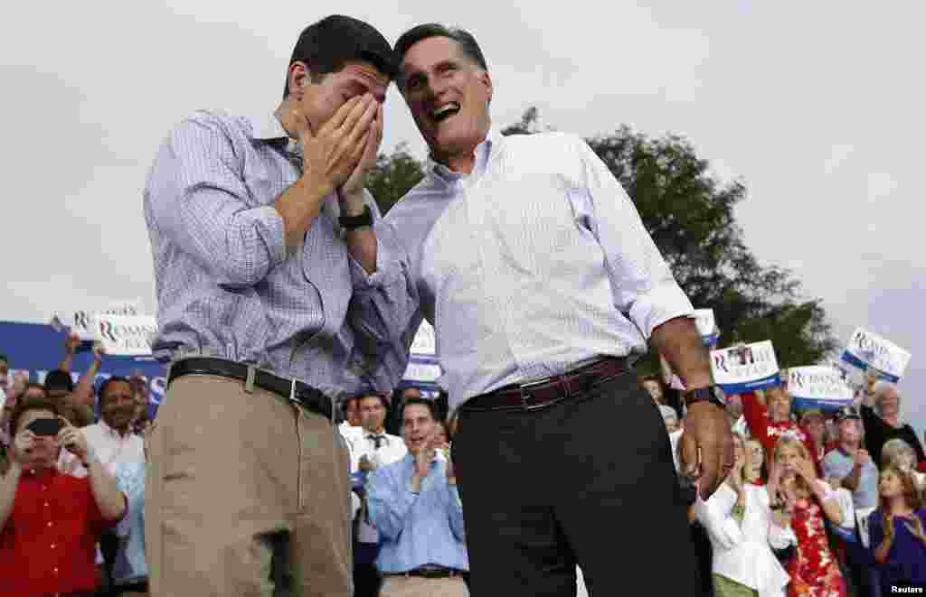 Митт Ромни улыбается реакции Пола Райана на публику, собравшуюся на предвыборный митинг в Ваукэш. Висконсин, 12 августа 2012 года.