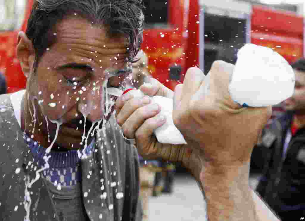 A protester has his eyes washed with milk to protect against tear gas, during clashes with police in Cairo November 21, 2011. REUTERS/Goran Tomasevic (EGYPT - Tags: POLITICS CIVIL UNREST TPX IMAGES OF THE DAY)