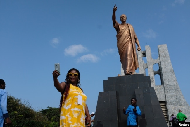 A member of a heritage tour group, traveling to Ghana to explore their ancestral roots, takes a selfie under the statue of Ghana's first president Kwame Nkrumah in Accra, August 7, 2019. Picture taken August 7, 2019. REUTERS/Francis Kokoroko