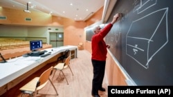 A teacher gives on-line lessons via webcam at the Politecnico University in Milan, Italy, Thursday, March 5, 2020. (Claudio Furlan/LaPresse via AP)