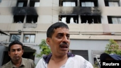 2013年5月8日，孟加拉国首都达卡的东海毛衣厂发生大火之后， 5月9日，制衣厂的一名负责人站在制衣厂的外面。