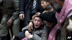 Ahmed, center, mourns his father Abdulaziz Abu Ahmed Khrer, who was killed by a Syrian Army sniper, during his funeral in Idlib, north Syria, Thursday, March 8, 2012. 