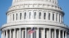 Bendera Amerika berkibar di Gedung Capitol AS, ketika Wal Kkota Muriel Bowser menyatakan keadaan darurat karena COVID-19 di Capitol Hill, Washington, AS, 18 Maret 2020. (Foto: Reuters / Tom Brenner)