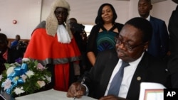 FILE - Newly elected Malawian president Peter Mutharika signs the oath book after he was sworn in, at the High Court in Blantyre, Malawi, May 31, 2014.