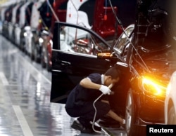 An employee works on an assembly line producing Mercedes-Benz cars at a factory of Beijing Benz Automotive Co. (BBAC) in Beijing, Aug. 31, 2015.