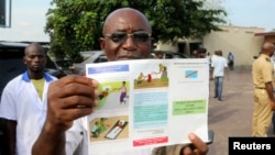A health worker displays an Ebola information leaflet for passengers at Ngobila Beach in Kinshasa, Democratic Republic of Congo, May 24, 2018. 