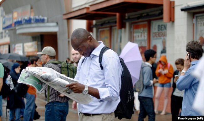 A mechanical engineering graduate student reads a newspaper at the University of Texas in Austin, Texas.