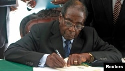 Zimbabwe President Robert Mugabe signs Zimbabwe's new constitution into law in Harare, May 22, 2013.