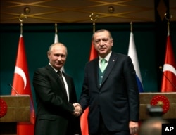 FILE - Turkey's President Recep Tayyip Erdogan, right, shakes hands with Russia's President Vladimir Putin following their joint news statement after their meeting at the Presidential Palace in Ankara, Turkey, Dec. 11, 2017. Relations between Turkey and Russia have been strained since 2015 but have been on the mend.