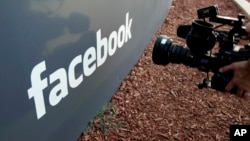 FILE - A television photographer shoots the sign outside of Facebook headquarters in Menlo Park, Calif., May 18, 2012.