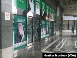 Posters on this wall outside a Riyadh mall depict the Saudi royal family, which is putting measures into place to encourage Saudi employment, Jan. 25, 2016.