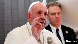 Pope Francis speaks with the media onboard a plane during his flight back from Tallinn after the final leg of his visit to the Baltic states, Estonia, Sept. 25, 2018.