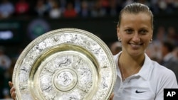 La campeona checa de tenis Petra Kvitova muestra el trofeo ganado en el torneo femenino de Wimbledon en 2014.