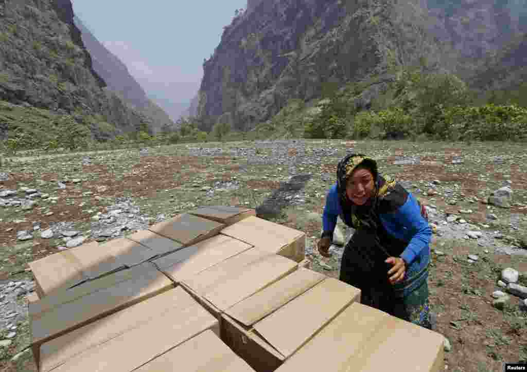 A woman helps unload emergency food supplies after the April 25 earthquake in Dovan, Nepal, May 8, 2015.