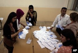 Election officials count ballots after the polls close in the controversial Kurdish referendum on independence from Iraq, in Irbil, Iraq, Sept. 25, 2017.