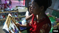 Seth Sreymom looks at the photo of her daughters on October 13, 2019. They died of drowning. (Kann Vicheika/VOA Khmer)