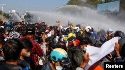 Polisi menembakkan meriam air ke arah para pengunjuk rasa yang berdemonstrasi menentang kudeta dan menuntut pembebasan Aung San Suu Kyi, di Naypyitaw, Myanmar. (Foto: Reuters)