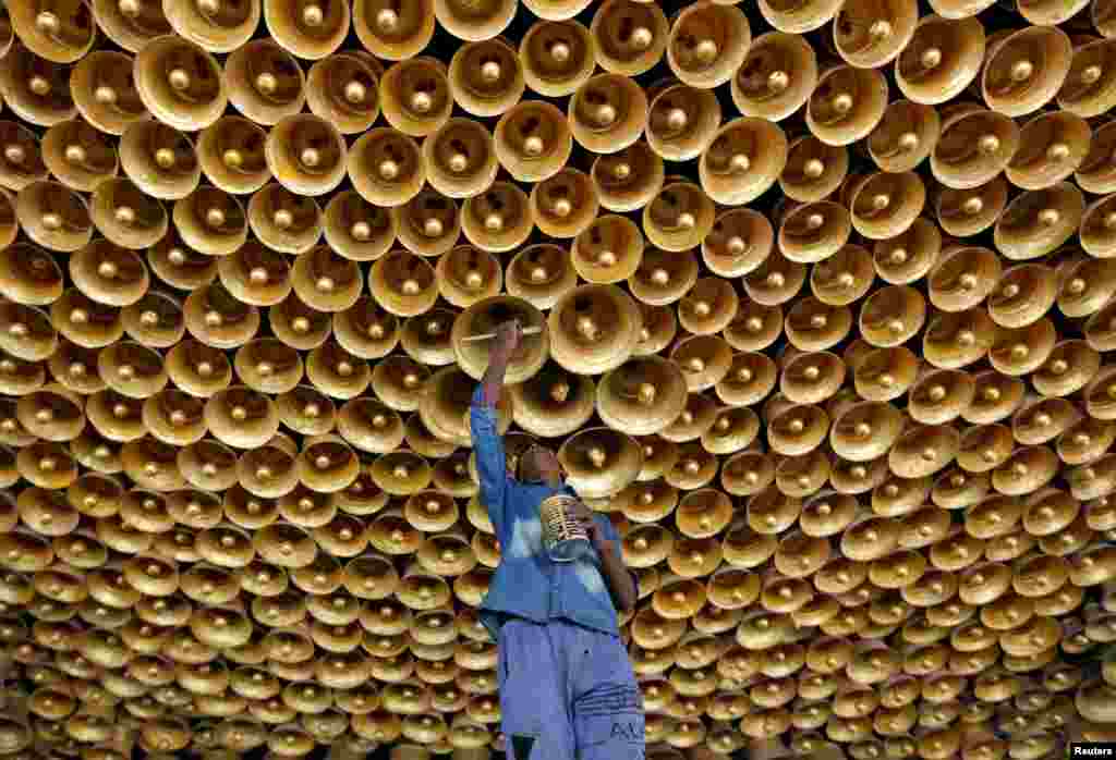 An artisan applies finishing touches to a decorative ceiling of a pandal or a temporary platform during preparations for the upcoming Hindu festival of Durga Puja in Kolkata, India.