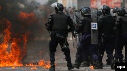 Des policiers congolais battent en retraite devant un cocktail Molotov à la périphérie de Kinshasa, République démocratique du Congo, 25 juillet 2006. EPA / NIC Bothma