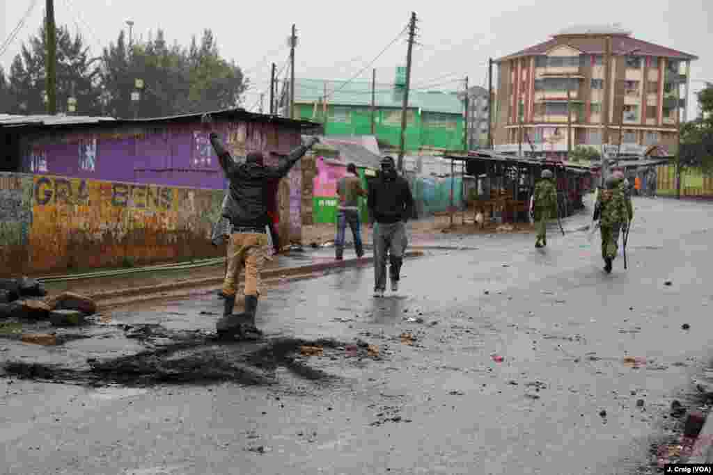 A man in Nairobi’s Kibera slum gestures at police after they instruct him to clear a roadblock, Oct. 26, 2017.