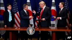 President Donald Trump hands a pen to South Korean President Moon Jae-In during a signing ceremony for the United States-Korea Free Trade Agreement during the United Nations General Assembly, Monday, Sept. 24, 2018, in New York. 