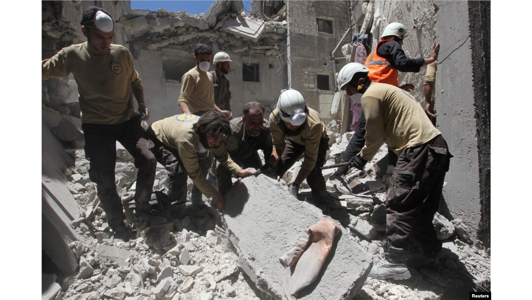 Arhiva - Pripadnici civilne zaštite tragaju za preživelima u ruševinama zgrade koja je uništena u vazdušnom udradu u pobunjeničkom gradu Ariha u pokrajini Idlib, Surija, 13. juli 2016.