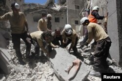 Arhiva - Pripadnici civilne zaštite tragaju za preživelima u ruševinama zgrade koja je uništena u vazdušnom udradu u pobunjeničkom gradu Ariha u pokrajini Idlib, Surija, 13. juli 2016.