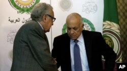 U.N.-Arab League envoy to Syria Lakhdar Brahimi, left, shakes hands with Arab League Secretary-General Nabil Elaraby following a joint press conference at the Arab League headquarters in Cairo, Egypt, December 30, 2012. 
