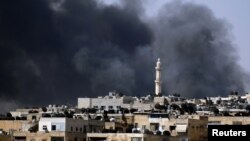 Smoke rises over the Salah al-Din neighborhood in central Aleppo during clashes between Free Syrian Army fighters and Syrian Army soldiers, August 4, 2012. 