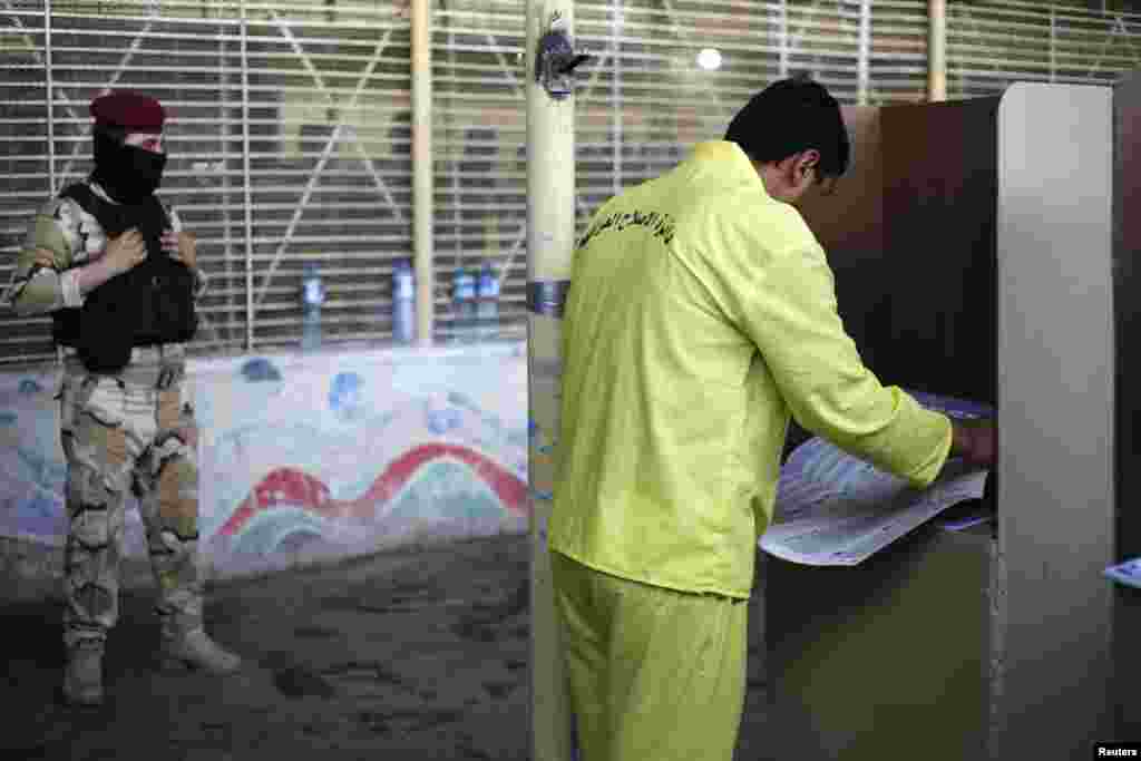 An Iraqi prisoner casts his vote inside al-Rusafa prison during early voting for the parliamentary election in Baghdad, April 28, 2014. Iraq will be holding its national elections on April 30. REUTERS/Ahmed Jadallah (IRAQ - Tags: ELECTIONS POLITICS) - RTR