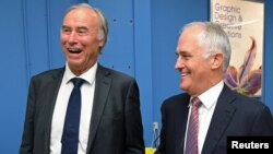 Conservative Liberal party MP John Alexander laughs as he stands with Australian Prime Minister Malcolm Turnbull during a visit to a printing company in Sydney, Australia, April 4, 2017.