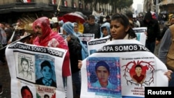 Người nhà và bạn bè của 43 sinh viên mất tích cầm chân dung của họ trong cuộc tuần hành ở thành phố Mexico, ngày 26/7/2015.