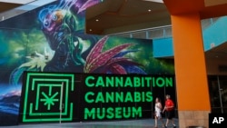 FILE - People walk by the Cannabition cannabis museum in Las Vegas, Sept. 18, 2018. The legal marijuana industry exploded in 2018, pushing its way further into the cultural and financial mainstream in the U.S. and beyond. 